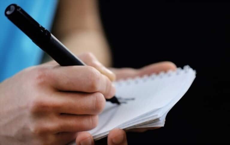 sportsman signing autograph on small notebook