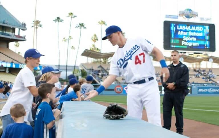 Baseball player reaching out to a young fan in the stands Baseball player reaching out to a young fan in the stands