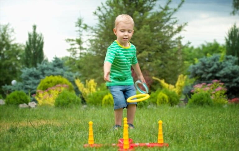 cute boy playing game throwing rings in the park cute boy playing game throwing rings in the park