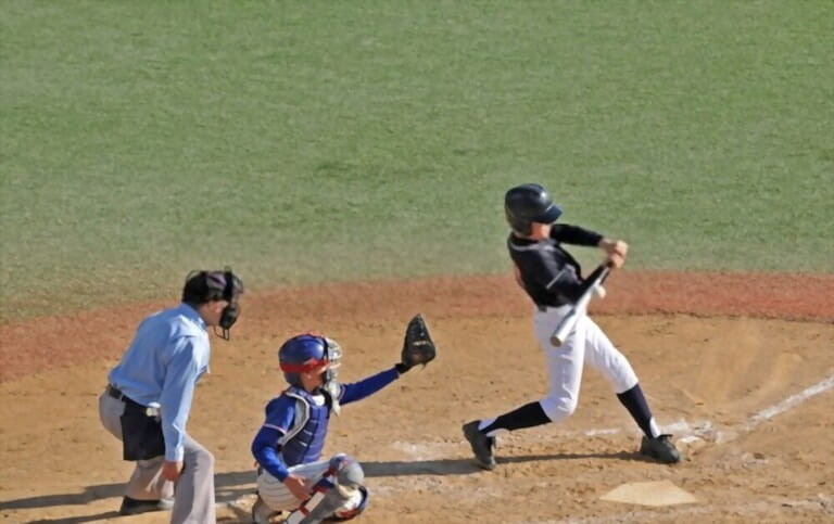 boys are playing volleyball in groups with a guy in the batting position