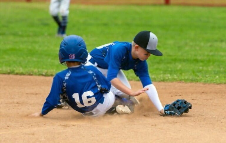 youth baseball player with blue uniform have collisions in the baseball stadium