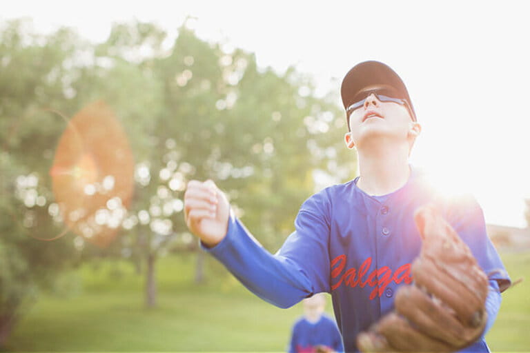 Young baseball player with baseball sunglasses looking up for fly ball. Young baseball player with baseball sunglasses looking up for fly ball.