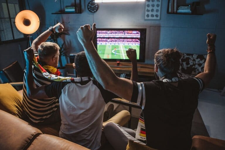 Excited football fans are watching the football match on tv Excited football fans are watching the football match on tv