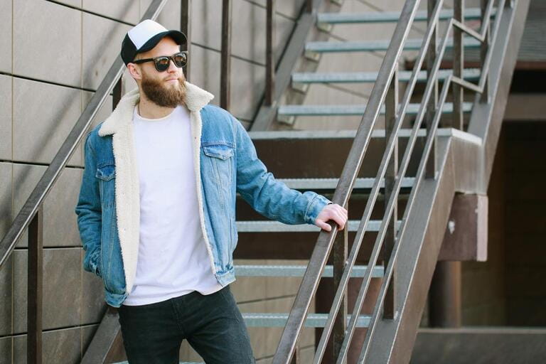 Hipster handsome male model with beard wearing white blank t-shirt and a baseball cap with space for your logo or design in casual urban style Hipster handsome male model with beard wearing white blank t-shirt and a baseball cap with space for your logo or design in casual urban style