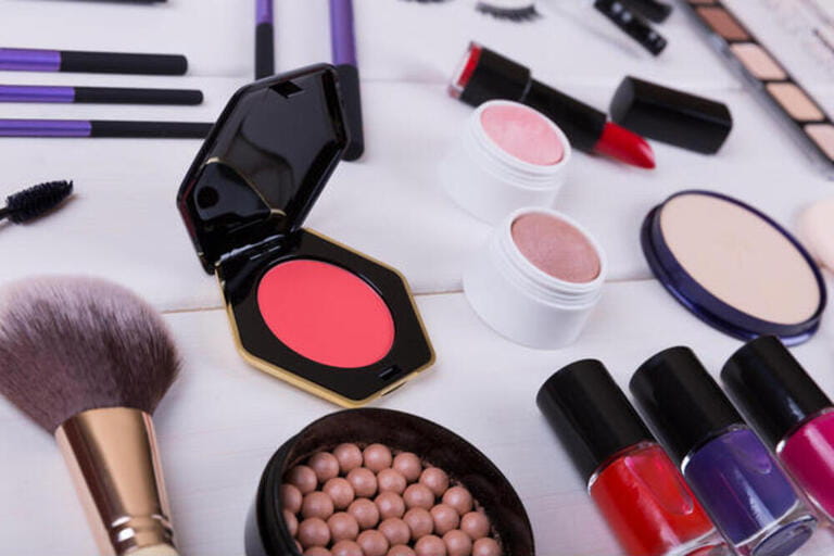collection of makeup cosmetics products on wooden table