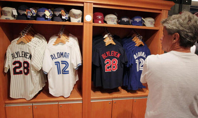Visitors to the National Baseball Hall of Fame gift shop check out the new jerseys on sale for inductees Bert Blyleven and Roberto Alomar in Cooperstown, New York