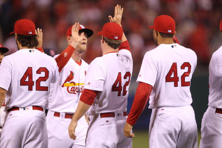 St. Louis Cardinals players line up to high five each other wearing the number 42 on every uniform, defeating the Cincinnati Reds 14-3 at Busch Stadium in St. Louis on April 15, 2016. Every team wore the number 42 on April 15 to honor the memory of Jackie Robinson.