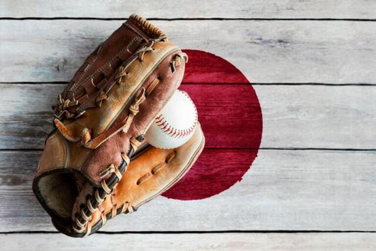 Leather baseball glove with ball on rustic wooden background with painted Japanese flag and copy space. Japan is one of the world's top baseball natio Leather baseball glove with ball on rustic wooden background with painted Japanese flag and copy space. Japan is one of the world's top baseball natio