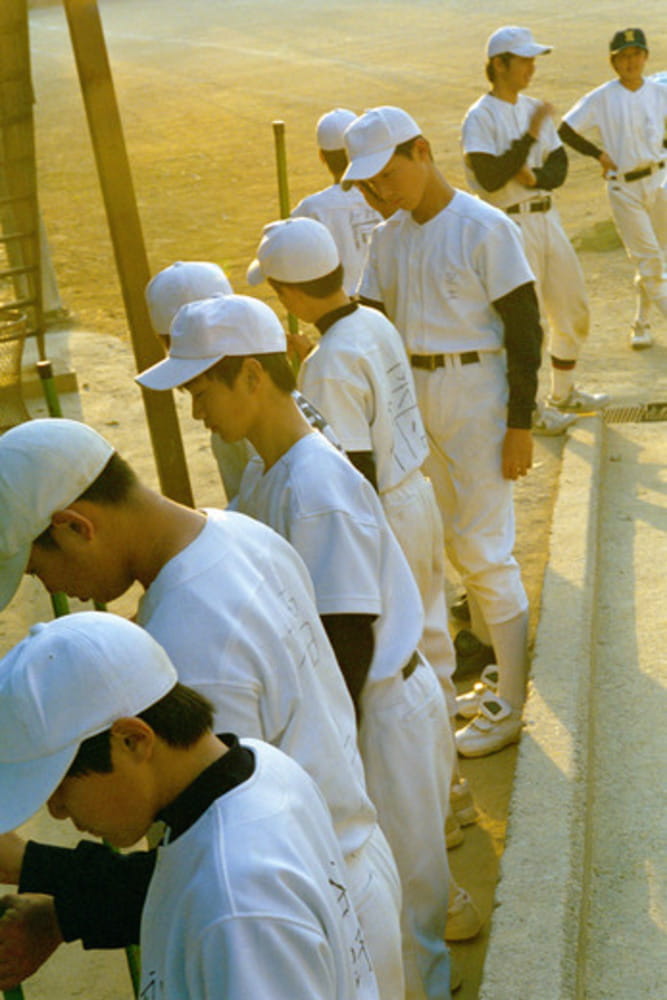 Young Japanese little league baseball players put away their equipment after a ball game in Kyoto Japan Young Japanese little league baseball players put away their equipment after a ball game in Kyoto Japan