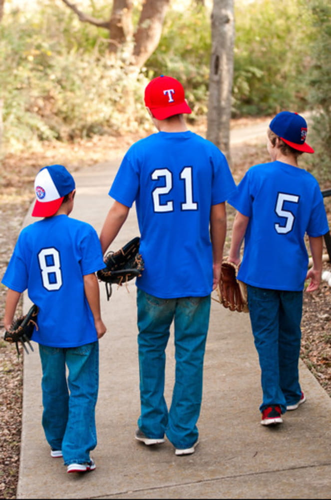 Three boys in jerseys and hats walking to park. Three boys in jerseys and hats walking to park.