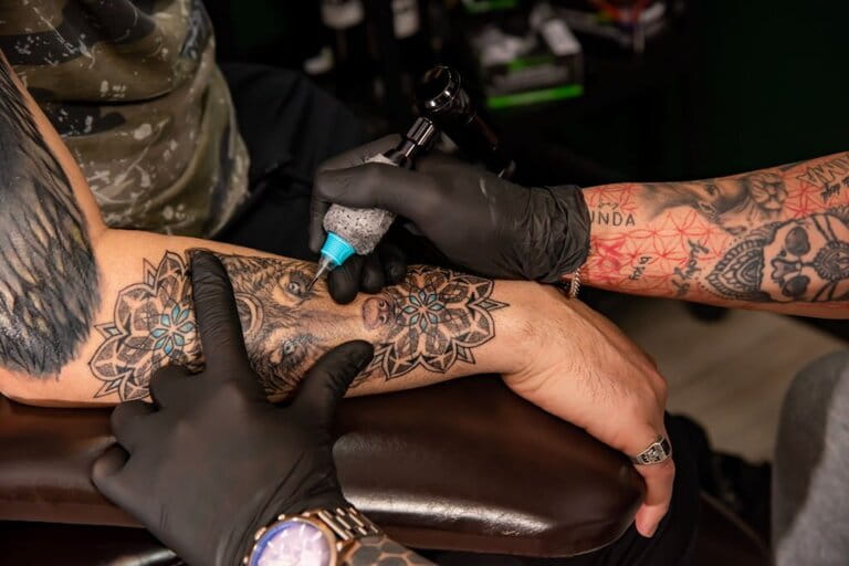 Professional tattoo artists perform hand tattoos using a tattoo machine in the studio Professional tattoo artists perform hand tattoos using a tattoo machine in the studio