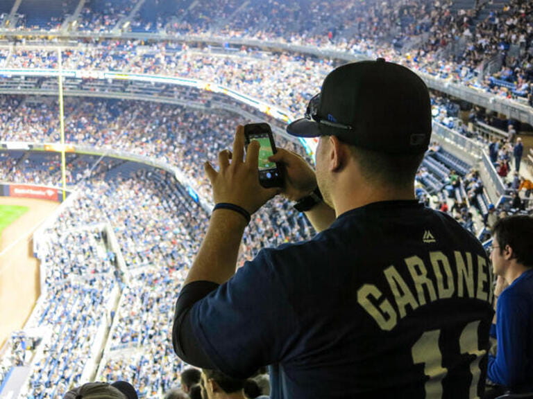 Fan at Yankee Stadium Baseball Game Taking cell phone photo, The Bronx, New York Fan at Yankee Stadium Baseball Game Taking cell phone photo, The Bronx, New York