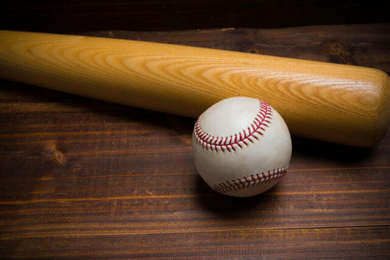 Baseball equipment: wooden bat and ball on a wood plank or bench background Baseball equipment: wooden bat and ball on a wood plank or bench background