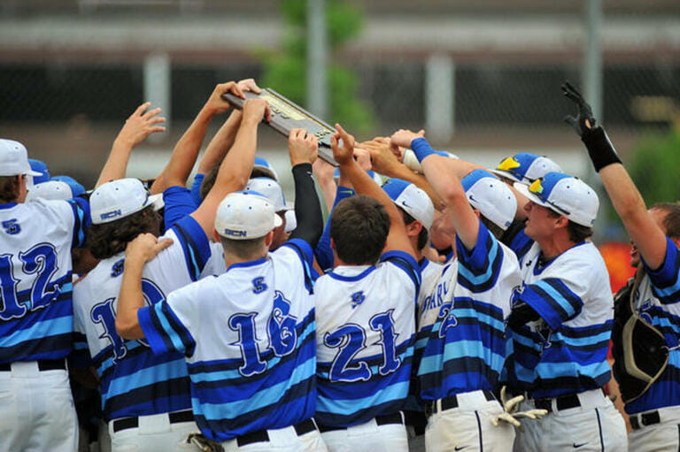 Players rally around a sectional championship plaque they has just won with an on-field victory. USA.