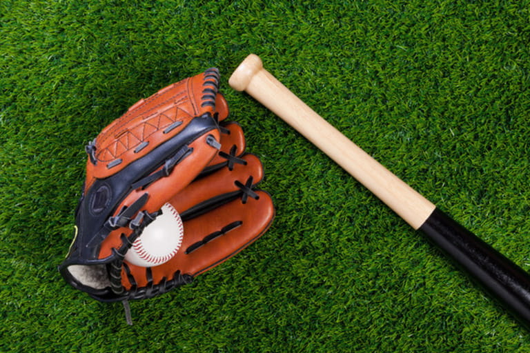 Photo of a Baseball glove bat and ball on grass
